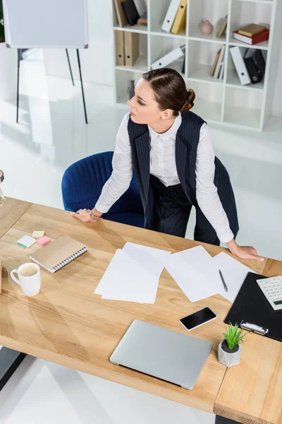 Бізнес-леді стоїть над офісним столом — стокове фото