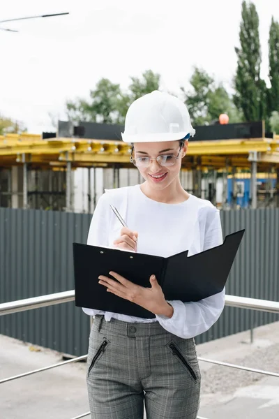 Affärskvinna på byggarbetsplats holding mapp — Stockfoto