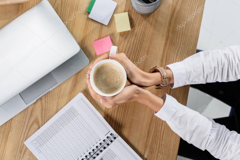 Businesswoman holding cup of coffee