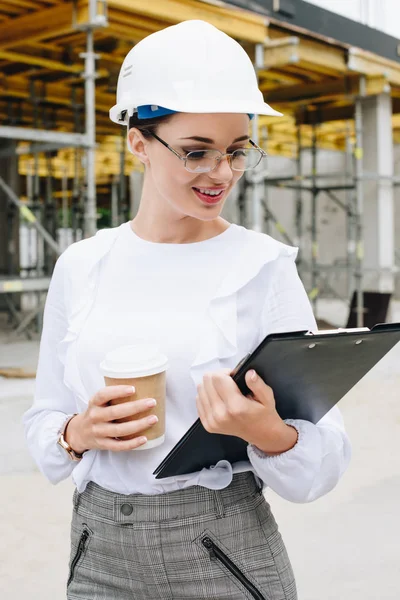 Engineer at construction holding clipboard — Free Stock Photo