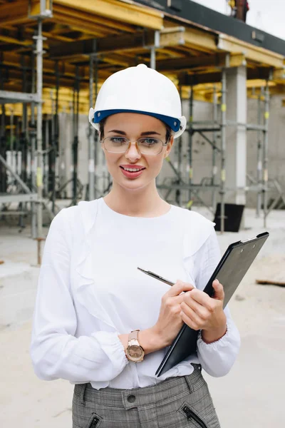 Engenheiro em hardhat segurando prancheta — Fotografia de Stock