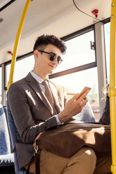 Homme utilisant un smartphone dans le bus de ville — Photo gratuite