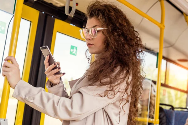 Woman using smartphone in city bus — Stock Photo, Image