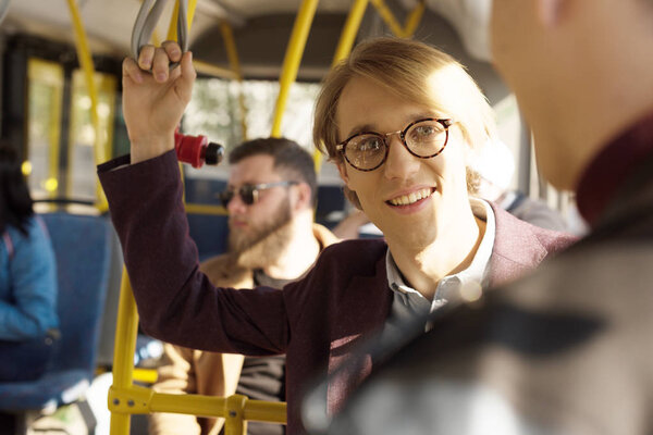 man in eyeglasses riding in city bus