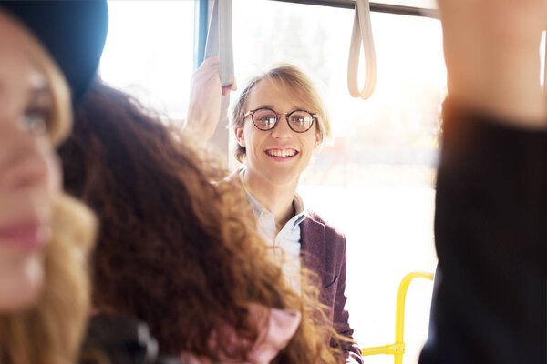 man in eyeglasses riding in city bus
