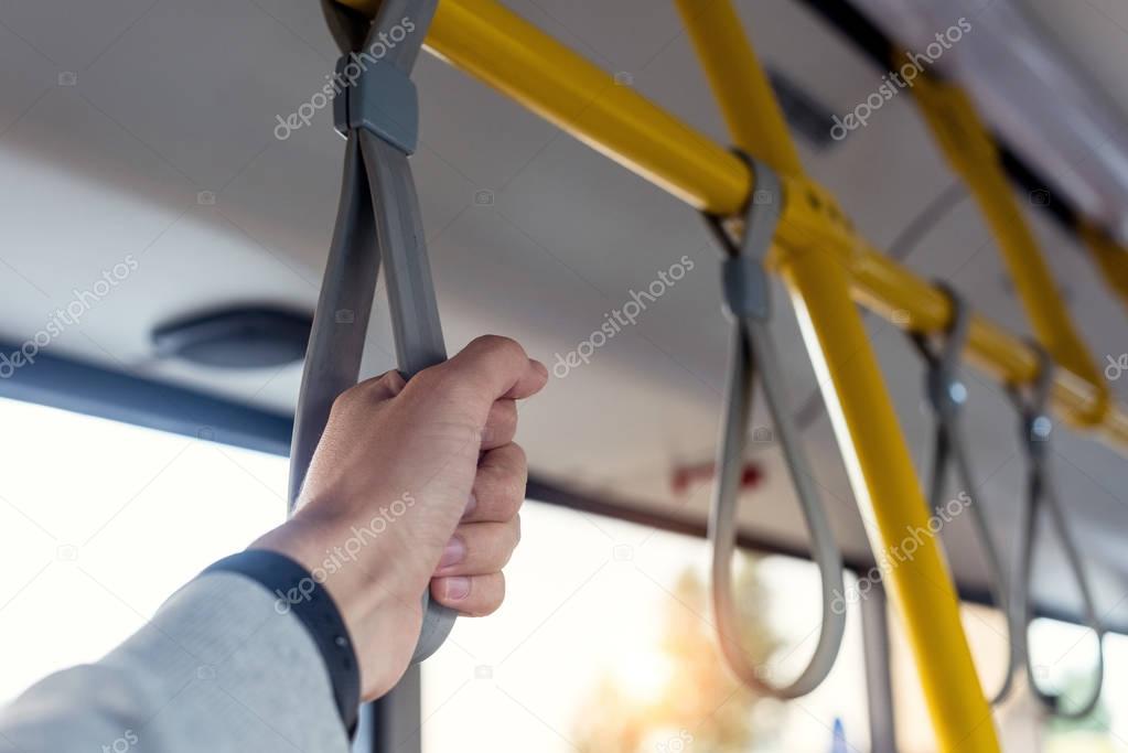 man holding bus handle