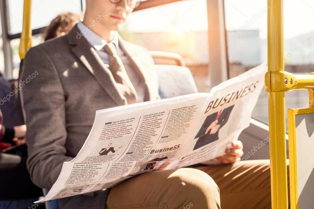 man with newspaper in bus