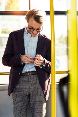 Otobüste smartphone ile gülümseyen adam