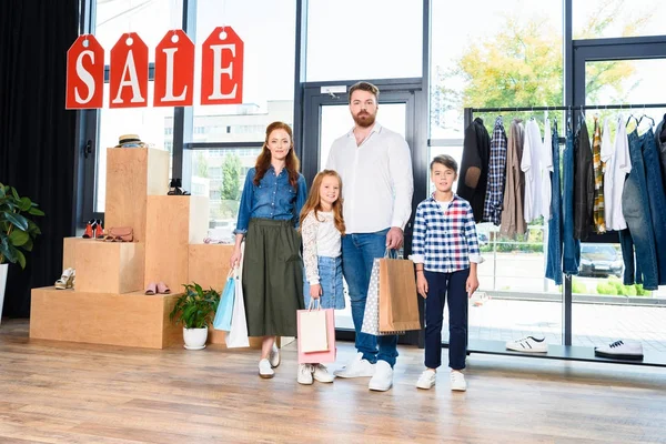 Family with shopping bags in boutique — Stock Photo, Image