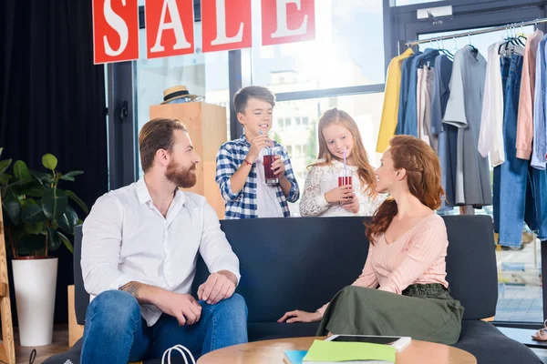 Familie ruht sich auf Sofa in Boutique aus — kostenloses Stockfoto