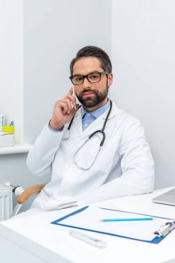 genç doktor telefonla konuşuyor