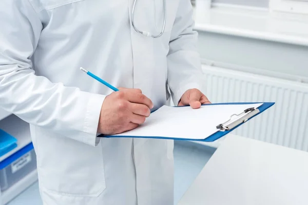 Doctor writing in clipboard — Stock Photo, Image