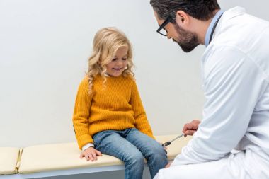 pediatrist making neurology examination for girl clipart