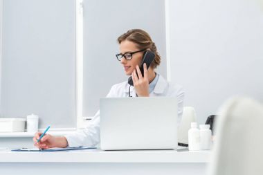 kadın doktor telefonla konuşuyor