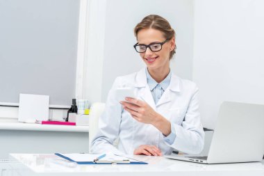 Akıllı telefon kullanan kadın doktor.