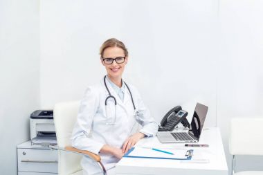 Ofiste oturan kadın doktor.