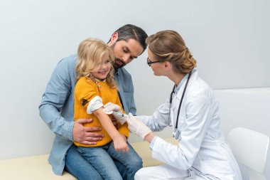 küçük kız için aşı yapıyor doktor