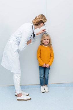 Doktor küçük kız yüksekliğini ölçme