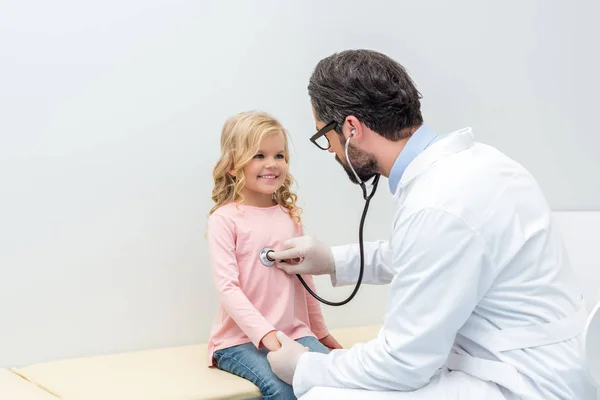 Pediatra escuchando el aliento de una niña — Foto de Stock