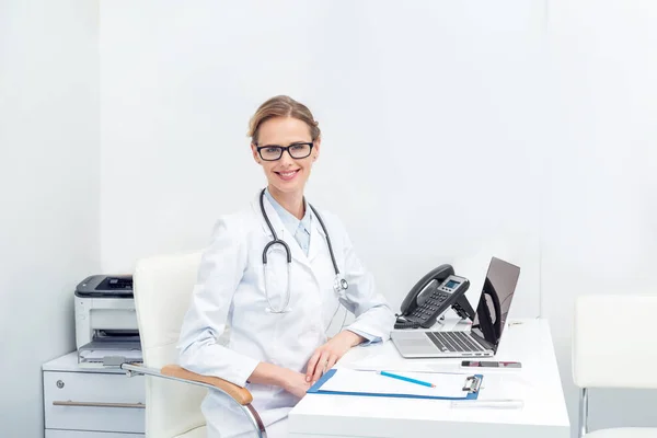 Médica mulher sentada no escritório — Fotografia de Stock