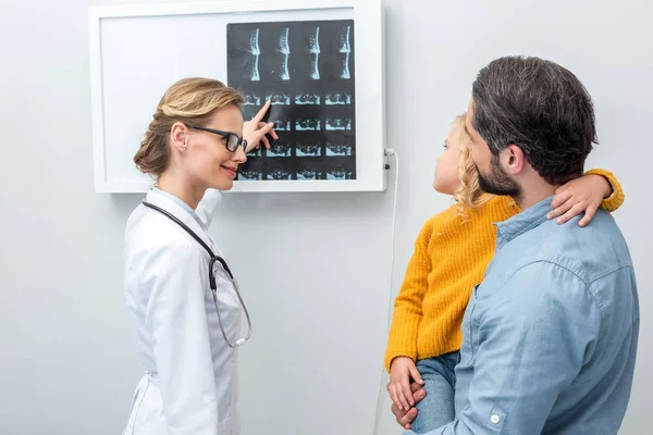 Médico que muestra exploraciones de rayos X a los pacientes — Foto de Stock