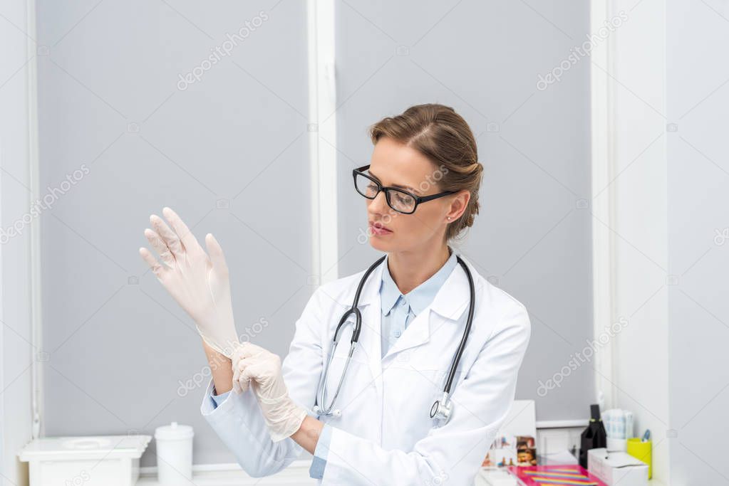 female doctor putting on gloves