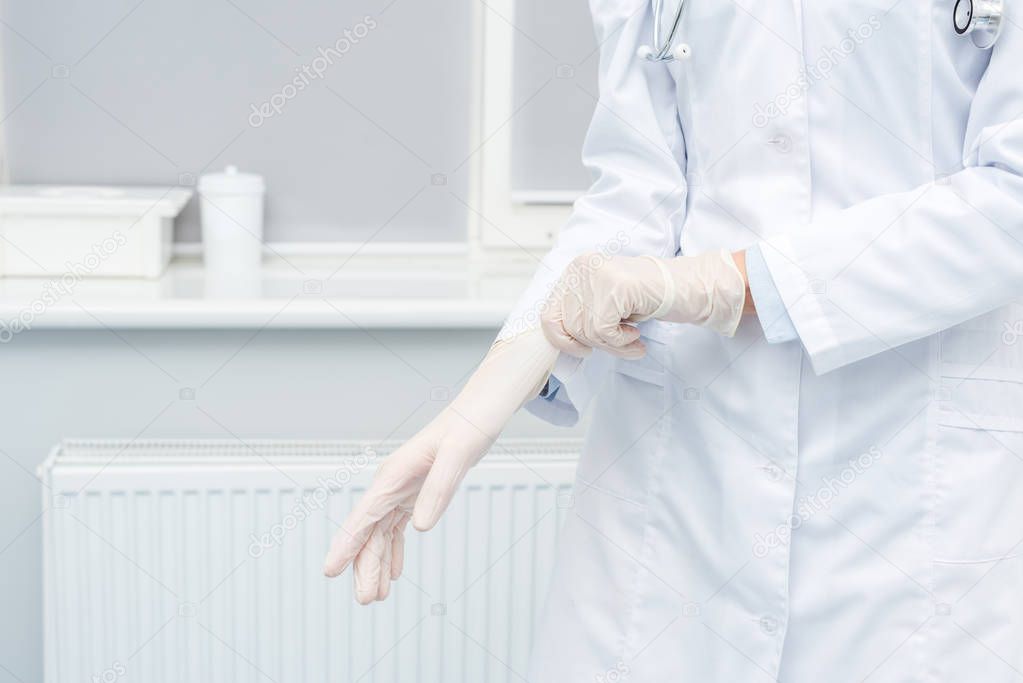 female doctor putting on gloves