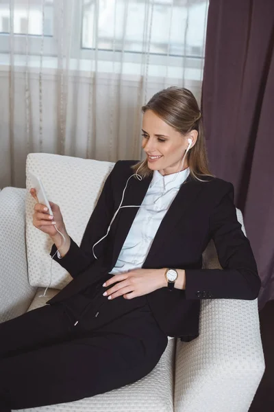 在酒店的房间里使用智能手机的女商人 — 免费的图库照片