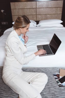 otel odasında dizüstü kullanarak iş kadını