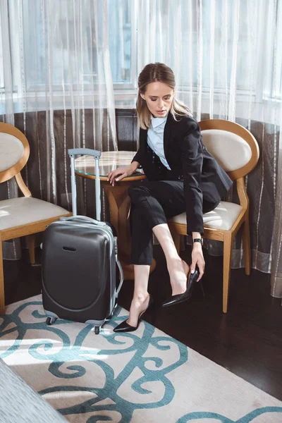 Businesswoman with high heeled shoes in hotel room — Stock Photo, Image