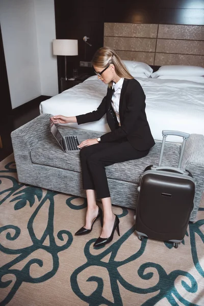 Femme d'affaires utilisant un ordinateur portable dans la chambre d'hôtel — Photo