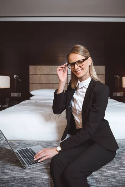 Empresaria usando laptop en habitación de hotel — Foto de stock gratis