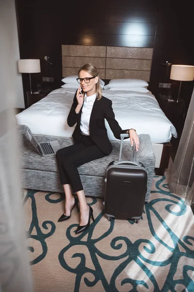Femme d'affaires utilisant un smartphone dans la chambre d'hôtel — Photo
