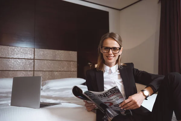 Businesswoman reading magazine in hotel — Stock Photo, Image