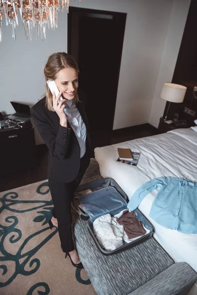 Podnikatelka pomocí smartphone v hotelovém pokoji — Stock fotografie zdarma
