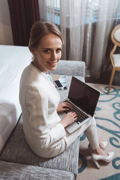 Businesswoman using laptop in hotel room — Free Stock Photo