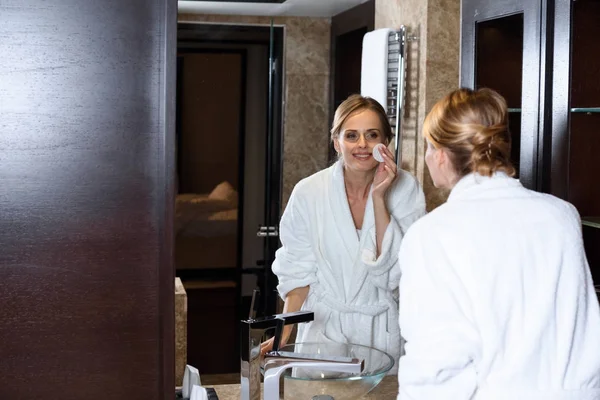 Woman in bathrobe applying makeup — Free Stock Photo