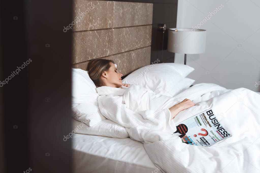 woman with magazine sleeping in bed 