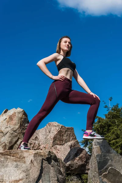 Mujer en forma en rocas — Foto de stock gratis