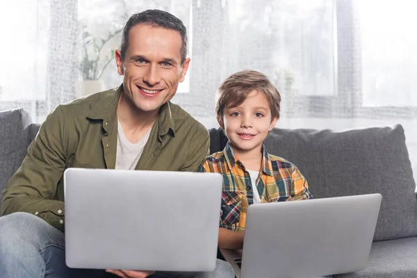 Отец и сын с ноутбуками — стоковое фото