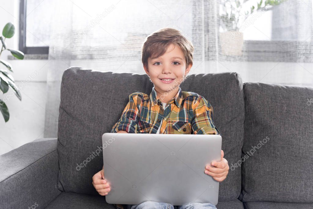 boy with laptop sitting on couch