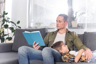father reading book for son clipart
