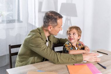 Baba, Oğul 'a ödevlerinde yardım ediyor.