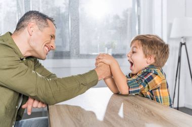 father and son arm wrestling together clipart