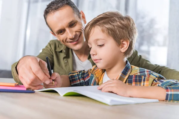 Ojciec pomagający synowi w zadaniach domowych — Zdjęcie stockowe