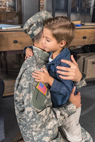 Ayah dalam seragam militer memeluk anak — Foto Stok Gratis