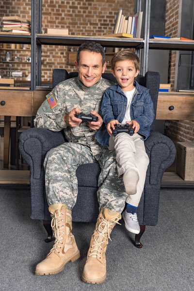 father and son playing console with gamepads
