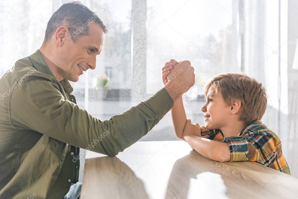 father and son arm wrestling together