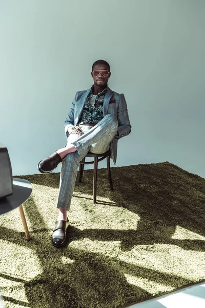 Mann im schicken Anzug posiert auf Stuhl — Stockfoto