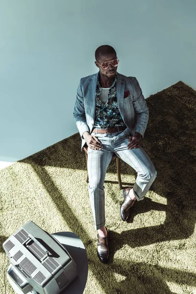 Mannen i fashionabla kostym poserar på stol — Stockfoto